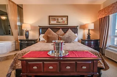 a bedroom with a large bed with a red table at Canalta High River in High River