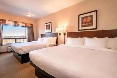 a hotel room with two beds and a window at Canalta High River in High River