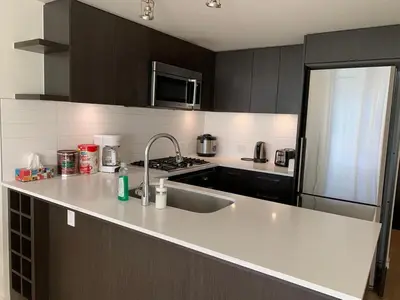 a kitchen with a sink and a stove top oven at Comfort in Richmond center 2bedr & good location in Richmond