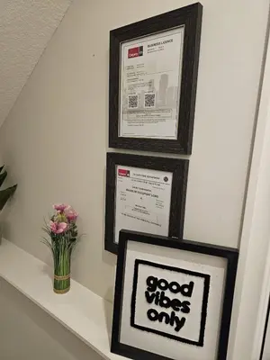 a shelf with two pictures and a vase of flowers at Brand-New Guesthouse-2bedrooms in Calgary