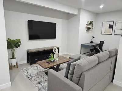 a living room with a couch and a flat screen tv at Brand-New Guesthouse-2bedrooms in Calgary