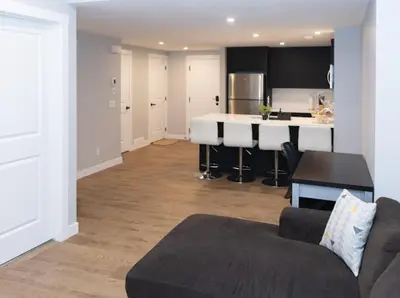 a living room with a couch and a kitchen at GoodVibes in Calgary