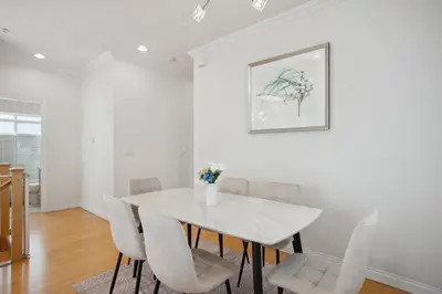 a white dining room with a white table and chairs at Bright and Comfy 3BR Home Ideal for Families in Vancouver