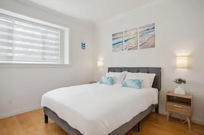 a white bedroom with a large bed and a window at Bright and Comfy 3BR Home Ideal for Families in Vancouver