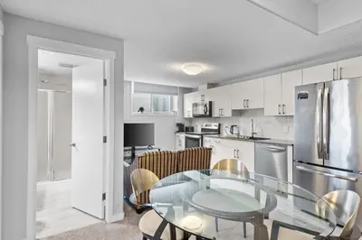 a kitchen and dining room with a glass table at Spacious 2BR Suite - SW Edmonton in Edmonton