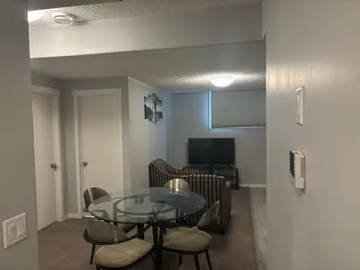 a dining room with a glass table and chairs at Spacious 2BR Suite - SW Edmonton in Edmonton