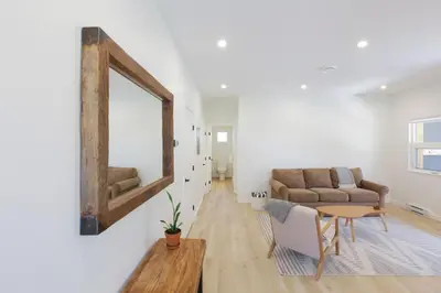 a living room with a mirror and a couch at Aurelia Guest Suite and Sauna in Tofino