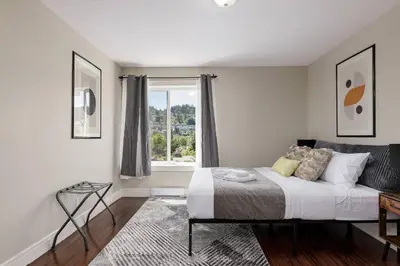 a bedroom with a bed and a window at Peaceful spacious 2BR Suite in Nanaimo