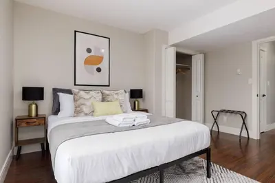 a white bedroom with a large white bed in it at Peaceful spacious 2BR Suite in Nanaimo