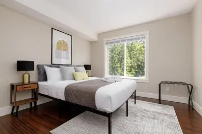 a bedroom with a large bed and a window at Peaceful spacious 2BR Suite in Nanaimo