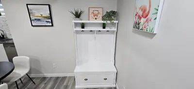 a white cabinet with plants on a wall at Bleniel Place - Stylish Basement Suite with Wi-Fi Netflix & Parking in Edmonton