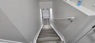 a stairway leading up to a room with white walls at Bleniel Place - Stylish Basement Suite with Wi-Fi Netflix & Parking in Edmonton