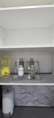 a shelf in a kitchen with jars and baskets at Bleniel Place - Stylish Basement Suite with Wi-Fi Netflix & Parking in Edmonton
