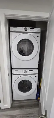 a washer and dryer in a small room at Bleniel Place - Stylish Basement Suite with Wi-Fi Netflix & Parking in Edmonton