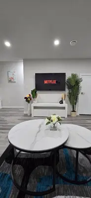 a living room with a table with flowers on it at Bleniel Place - Stylish Basement Suite with Wi-Fi Netflix & Parking in Edmonton