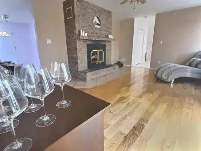 a group of wine glasses sitting on a counter in a living room at Spacious Getaway Two Homes on a Tranquil Vineyard Ideal for Large Groups in Keremeos
