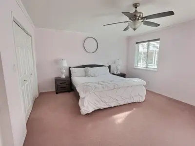 a white bedroom with a bed and a ceiling fan at Spacious Getaway Two Homes on a Tranquil Vineyard Ideal for Large Groups in Keremeos