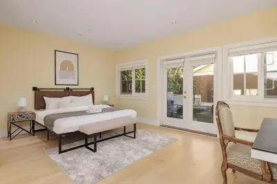 a bedroom with a bed and a table and chairs at Charming Luxury Home near DT and Lonsdale Quay in North Vancouver