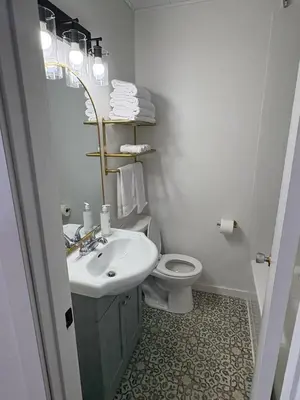 a white bathroom with a sink and a toilet at Remo Stays in Unity