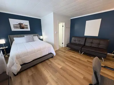 a bedroom with blue walls and a bed and a couch at Remo Stays in Unity