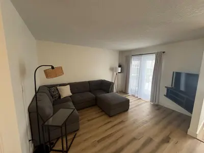a living room with a couch and a flat screen tv at Alpenglow Oasis in Hinton