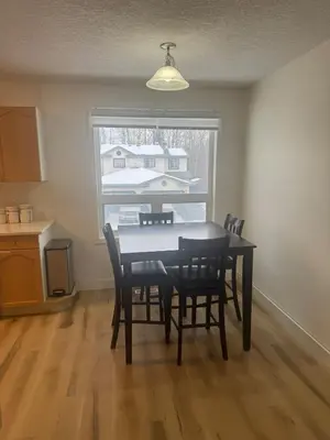 a dining room with a table and chairs and a window at Alpenglow Oasis in Hinton
