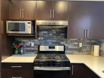 a kitchen with a stove and a microwave at Sunlit Haven in Calgary