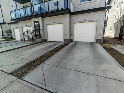 a driveway with three garage doors in front of a house at Sunlit Haven in Calgary