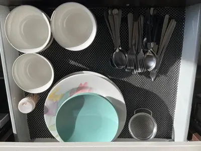 a drawer filled with white plates and silver utensils at Sunlit Haven in Calgary