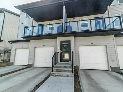 a house with two garage doors and a balcony at Sunlit Haven in Calgary