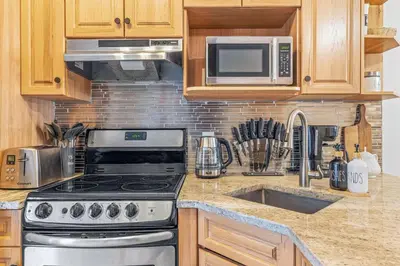 a kitchen with a stove and a microwave at Scenic 2BR Haven with MTN Views Near DT Banff in Canmore