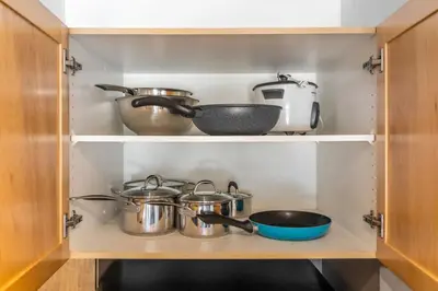 a kitchen with pots and pans on a shelf at 2BR Mystic Springs Escape with BBQ, Pool, Hot tub in Canmore