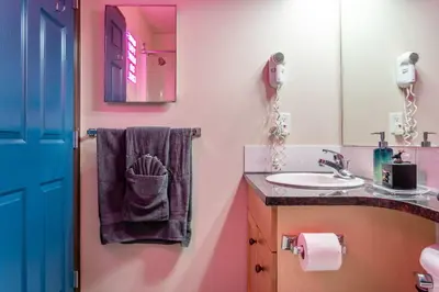a bathroom with a sink and a mirror at 2BR Mystic Springs Escape with BBQ, Pool, Hot tub in Canmore