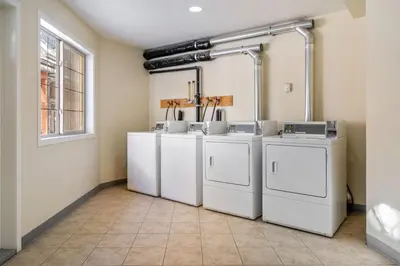 a room with four washing machines and a window at 2BR Mystic Springs Escape with BBQ, Pool, Hot tub in Canmore