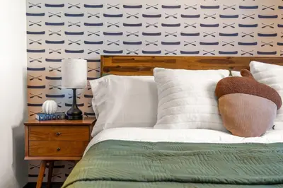 a bedroom with a bed with a blue and white wallpaper at 2BR Mystic Springs Escape with BBQ, Pool, Hot tub in Canmore