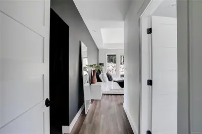 a hallway with white walls and a living room at Shawnigan Lake Retreat with Theatre in Shawnigan Lake