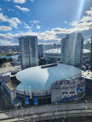 a large building with a rink in front of a city at Modern High-Rise 1 Bedroom Condo with water view near stadiums in Vancouver