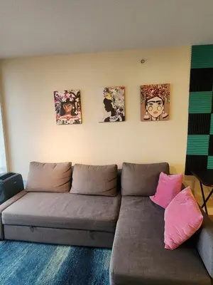 a living room with a couch and four pictures on the wall at Modern High-Rise 1 Bedroom Condo with water view near stadiums in Vancouver