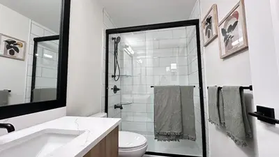 a bathroom with a shower and a toilet and a sink at Birdie on the Hill in Mission City