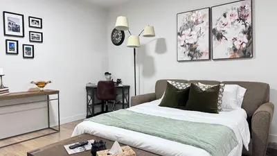 a bedroom with a bed and a table and a clock at Birdie on the Hill in Mission City
