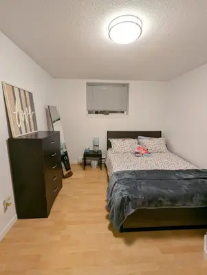 a bedroom with a bed and a dresser in it at Walnut Grove Gem in Langley