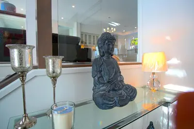 a statue sitting on a glass table with two glasses at Peaceful Coquitlam Escape, Modern New Home, Minutes to Transit in Coquitlam