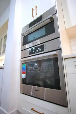 two ovens in a kitchen with white cabinets at Peaceful Coquitlam Escape, Modern New Home, Minutes to Transit in Coquitlam