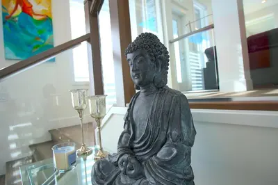 a statue of a buddha sitting on a table at Peaceful Coquitlam Escape, Modern New Home, Minutes to Transit in Coquitlam