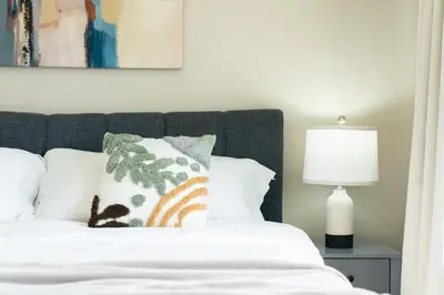 a bedroom with a bed with white sheets and pillows at Sunnymede Vacation Stay in Richmond