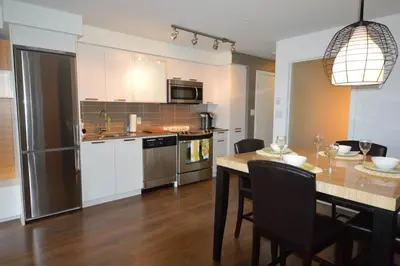 a kitchen and dining room with a table with chairs at Be Close To Chinatown When You Are In The Union Building in Victoria