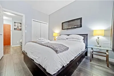 a bedroom with a large bed with a tv on the wall at Cozy 1 Bedroom Downtown Central in Vancouver