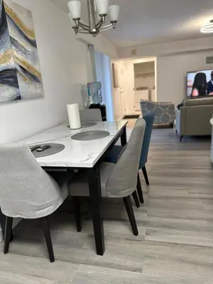 a dining room table and chairs in a living room at 2bedroom, 2bed day light Suite in a nice and secured neighborhood in Prince George