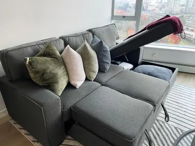 a couch with pillows on it in a living room at Condo Downtown Vancouver - Near Rogers Arena & BC Place w Parking in Vancouver