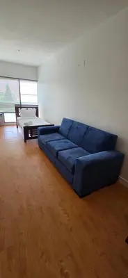 a large blue couch in a living room at New Royal Inn in New Westminster